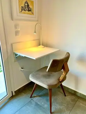 a chair sitting next to a desk with a lamp at Kalliopis Apartment in Athens