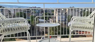 two white chairs and a table on a balcony at Kalliopis Apartment in Athens