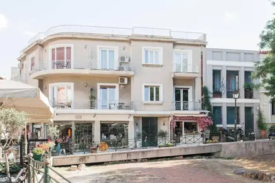 a large white building with balconies and tables at Diogenis' Jug in Athens