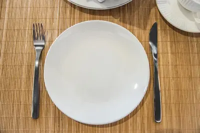 a white plate with a fork and knife on a table at P & I in Athens