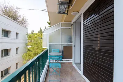 a balcony with two blue stools on a building at Renovated Apartment next to Panathenaic Stadium in Athens