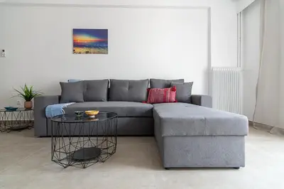 a living room with a grey couch and a table at Renovated Apartment next to Panathenaic Stadium in Athens