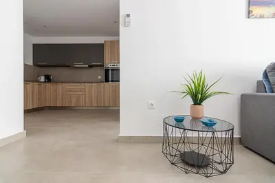 a living room with a table and a kitchen at Renovated Apartment next to Panathenaic Stadium in Athens
