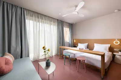 a hotel room with two beds and a couch at Alkima Athens Wellness Stay in Athens