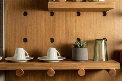 a wooden shelf with three dishes and a plant on it at Alkima Athens Wellness Stay in Athens
