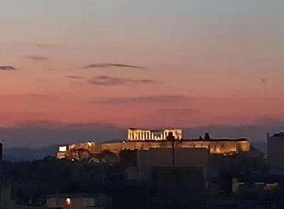 a building with lights on top of it at sunset at Athens Christina's Acropolis Apartment in Athens