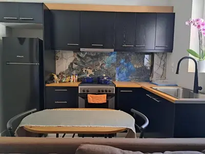 a kitchen with blue cabinets and a table and a sink at Athens Christina's Acropolis Apartment in Athens