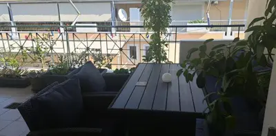 a wooden table with pillows on a balcony with plants at Athens Christina's Acropolis Apartment in Athens
