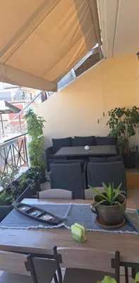a table with chairs and a table with a plant on it at Athens Christina's Acropolis Apartment in Athens