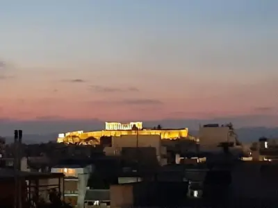 a building with a sign on top of it at sunset at Athens Christina's Acropolis Apartment in Athens