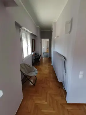 a hallway with a hard wood floor and a window at Penthouse spacious w super wifi & terrace, 2 min from metro in Athens