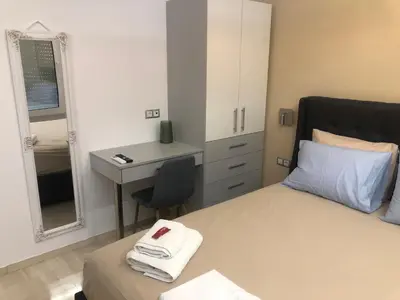 a bedroom with a bed and a desk and a mirror at ROYAL RED SUITE NO 1, PIRAEUS PORT in Piraeus