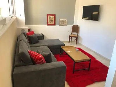 a living room with a couch and a red rug at ROYAL RED SUITE NO 1, PIRAEUS PORT in Piraeus