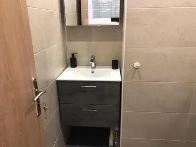 a small bathroom with a sink and a door at ROYAL RED SUITE NO 1, PIRAEUS PORT in Piraeus