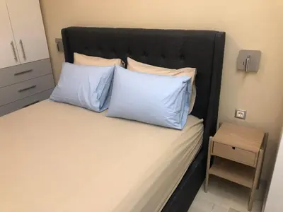 a bedroom with a bed with two blue pillows at ROYAL RED SUITE NO 1, PIRAEUS PORT in Piraeus