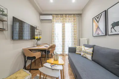 a living room with a couch and a table at Elegant Mavili Suite by CloudKeys in Athens