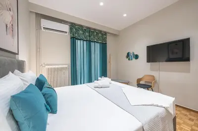 a bedroom with a large white bed with blue pillows at Elegant Mavili Suite by CloudKeys in Athens