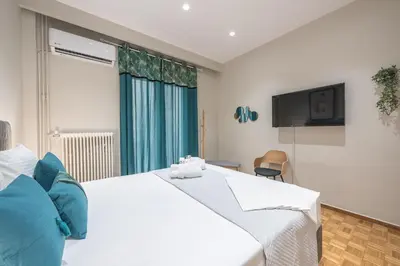 a bedroom with a large white bed and a television at Elegant Mavili Suite by CloudKeys in Athens