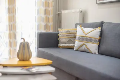 a blue couch with pillows and a pumpkin on a table at Elegant Mavili Suite by CloudKeys in Athens