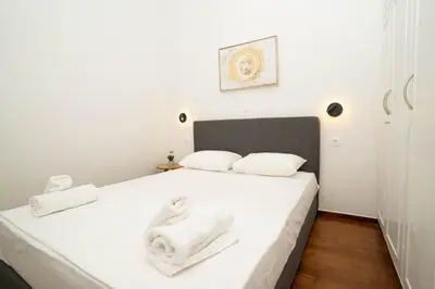 a bedroom with a white bed with towels on it at AthensBlues Glyfada Premium in Athens