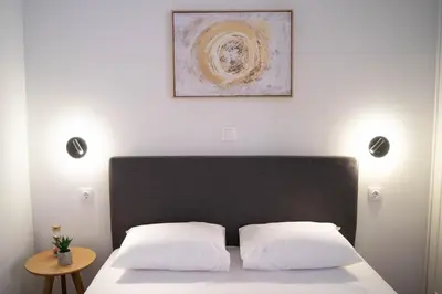 a bed with two white pillows and a picture on the wall at AthensBlues Glyfada Premium in Athens