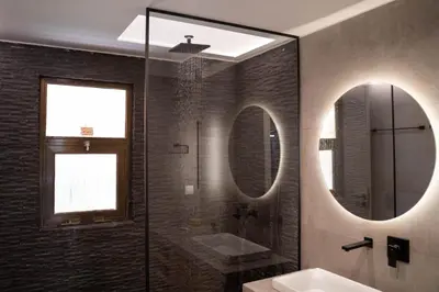 a bathroom with a shower and a sink and a mirror at AthensBlues Glyfada Premium in Athens