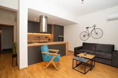 a living room with a couch and a bike hanging on the wall at AthensBlues Glyfada Premium in Athens