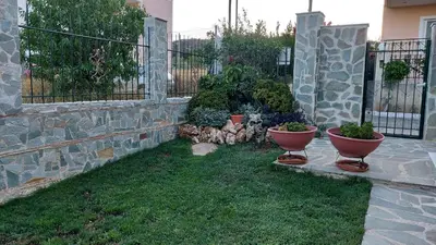 a garden with two vases on the grass next to a fence at SHLEY House 1 in Artemida