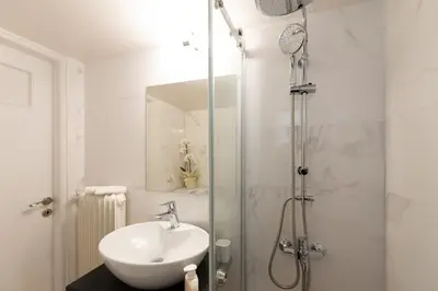 a bathroom with a sink and a shower at MEDLUXE BUSINESS Apartment in Athens