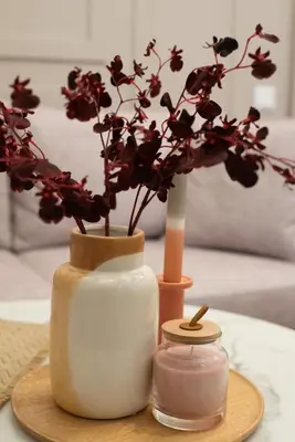 a table with two vases with flowers and a candle at MEDLUXE BUSINESS Apartment in Athens