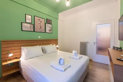 a bedroom with a white bed with towels on it at MEDLUXE BUSINESS Apartment in Athens