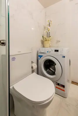 a bathroom with a toilet and a washing machine at MEDLUXE BUSINESS Apartment in Athens