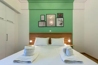 a bedroom with a large white bed with two towels at MEDLUXE BUSINESS Apartment in Athens