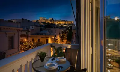 a table on a balcony with a view of the acropolis at Acropolis apartment with a unique view 2 in Athens