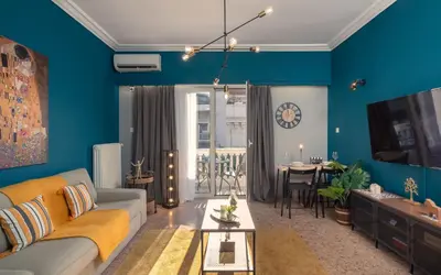 a living room with blue walls and a couch at Acropolis apartment with a unique view 2 in Athens
