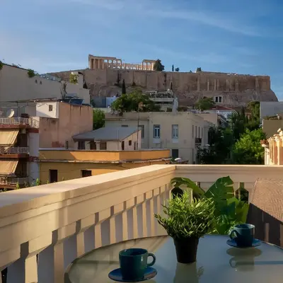 a table with two cups on top of a balcony at Acropolis apartment with a unique view 2 in Athens