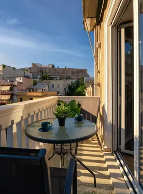 a table on a balcony with a view of a city at Acropolis apartment with a unique view 2 in Athens