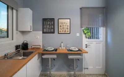 a kitchen with a sink and a counter with stools at Acropolis apartment with a unique view 2 in Athens