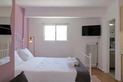 a bedroom with a white bed with towels on it at Cozy Studio in Koukaki Athens BY ZAIN in Athens