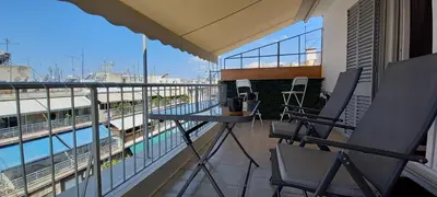 a balcony with a table and chairs and a pool at Cozy Studio in Koukaki Athens BY ZAIN in Athens