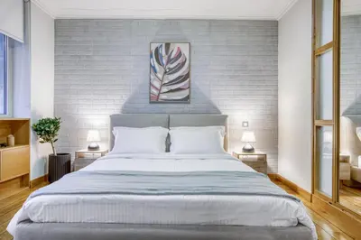 a bedroom with a large bed and two lamps at Monastiraki Stylish Loft W/ Acropolis View/Bathtub in Athens