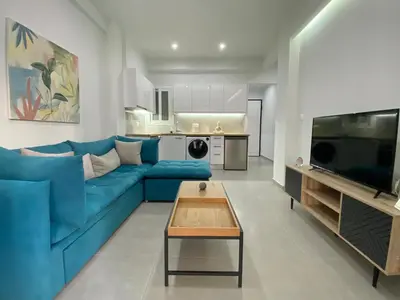a living room with a blue couch and a table at Luxury 1 Bedroom Flat in Athens