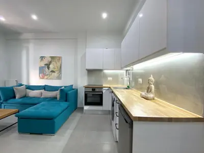 a kitchen with a blue couch and a kitchen counter at Luxury 1 Bedroom Flat in Athens