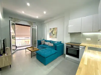 a living room with a blue couch in a kitchen at Luxury 1 Bedroom Flat in Athens