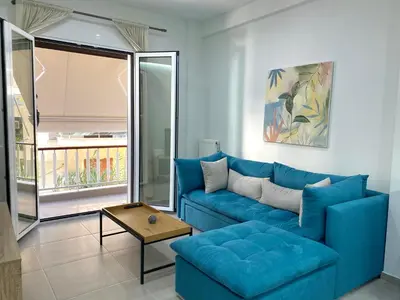 a living room with a blue couch and a table at Luxury 1 Bedroom Flat in Athens