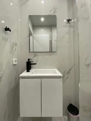 a white bathroom with a sink and a mirror at Luxury 1 Bedroom Flat in Athens