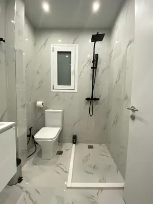 a white bathroom with a toilet and a mirror at Luxury 1 Bedroom Flat in Athens