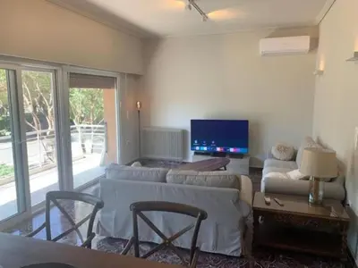 a living room with a couch and a tv at Flisvos Marina refurbished apartment in Athens