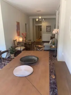 a wooden table with a plate on top of it at Flisvos Marina refurbished apartment in Athens