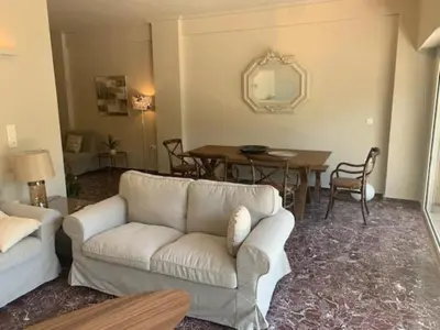a living room with a couch and a table at Flisvos Marina refurbished apartment in Athens